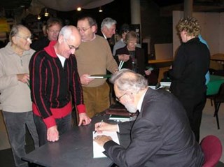 De auteur signeert zijn gedichtenbundel