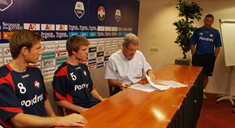 Trainer Gert Heerkens kijkt toe bij de ondertekening