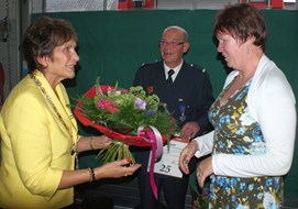 Mevrouw Spijkers krijgt bloemen omdat haar Hans Spijkers 25 jaar dient