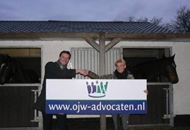 Esther Manders en Maikel den Otter met het bord van OJW-Advocaten 